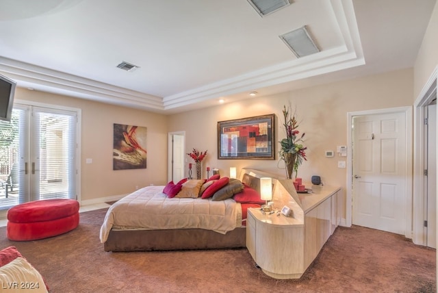 carpeted bedroom featuring access to exterior and a raised ceiling