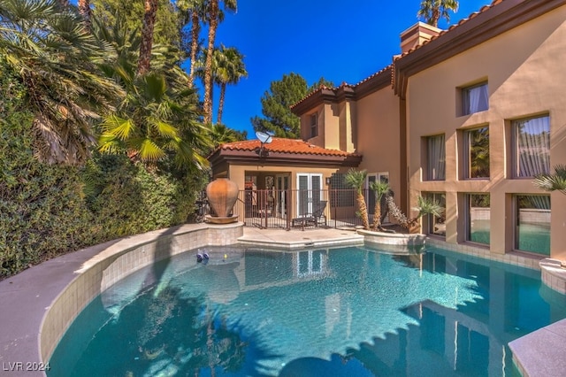 view of pool with french doors and a patio area