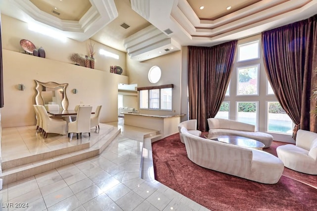 interior space with a high ceiling, light tile patterned floors, and a tray ceiling