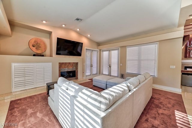 tiled living room featuring vaulted ceiling and a high end fireplace