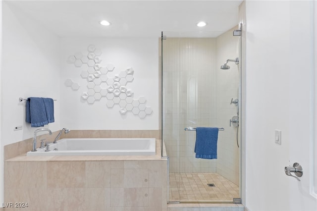 full bath with a stall shower, a bath, and recessed lighting