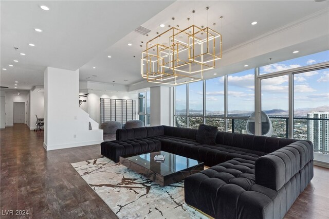 living room with crown molding, a notable chandelier, hardwood / wood-style floors, and floor to ceiling windows