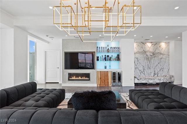 living room featuring beverage cooler, wood finished floors, baseboards, a bar, and crown molding