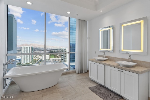 full bath with a view of city, a freestanding tub, a sink, and recessed lighting