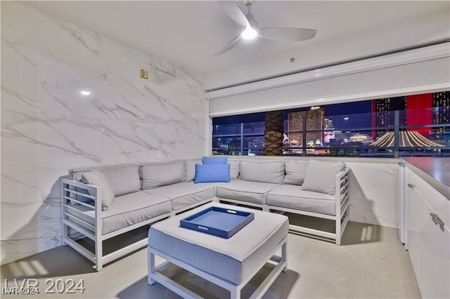 living room featuring concrete floors and a ceiling fan