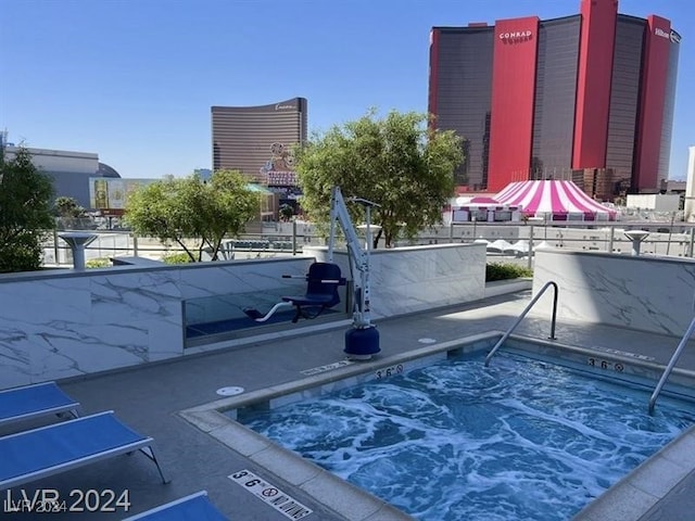 view of pool with a hot tub