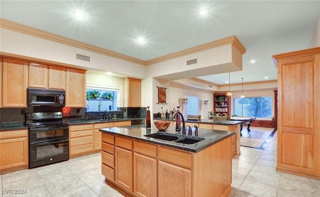 kitchen with sink, tasteful backsplash, dark stone countertops, a kitchen island with sink, and black appliances