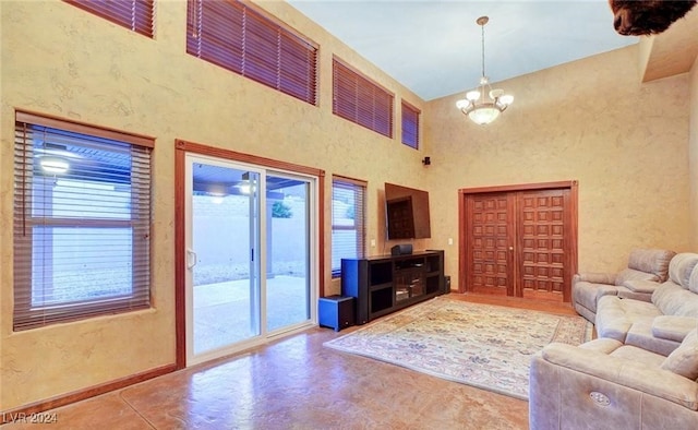 unfurnished living room featuring a high ceiling and a notable chandelier