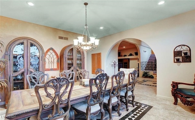 tiled dining room featuring an inviting chandelier