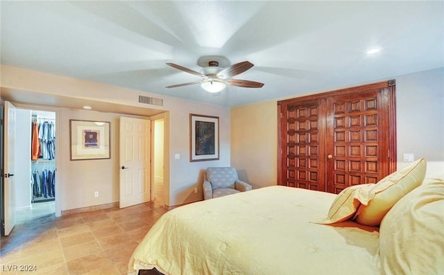 bedroom with a walk in closet, a closet, and ceiling fan