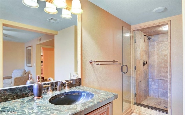 bathroom with vanity and a shower with door