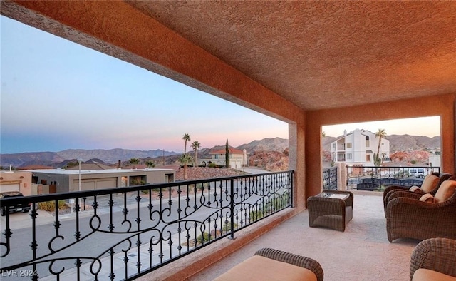 balcony at dusk featuring a mountain view