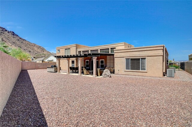 rear view of house featuring a mountain view, a patio, and central air condition unit