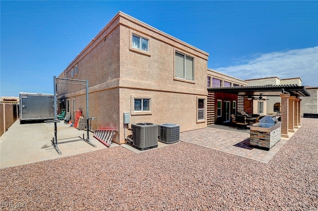 back of house with a pergola, a patio area, and central air condition unit