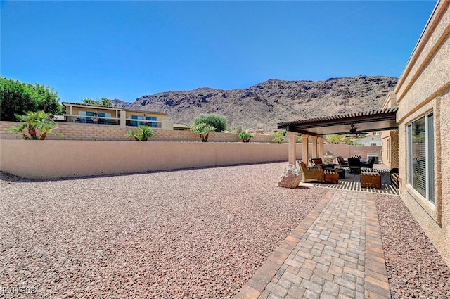 view of patio / terrace featuring a mountain view, outdoor lounge area, and ceiling fan