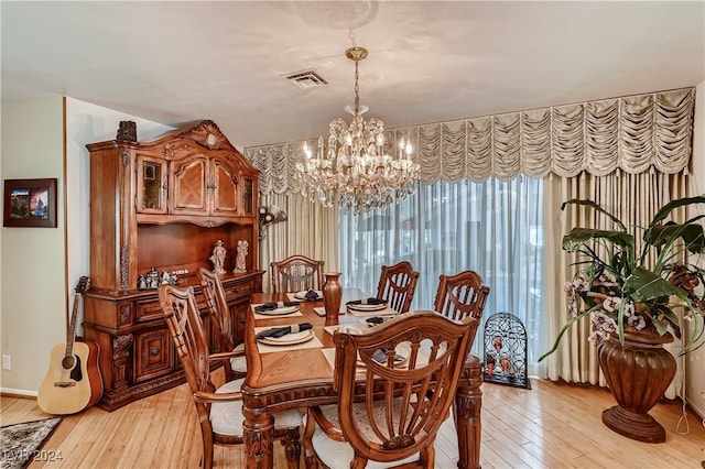 dining area with a notable chandelier and light hardwood / wood-style flooring