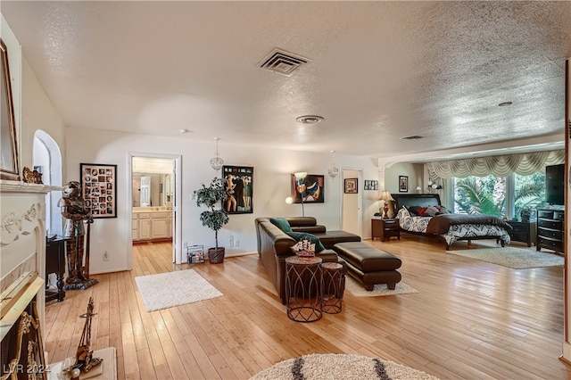 living room featuring light hardwood / wood-style flooring and a textured ceiling