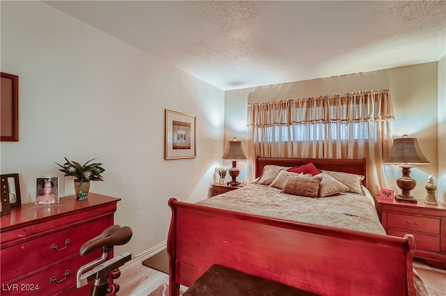 bedroom featuring a textured ceiling and light wood-type flooring