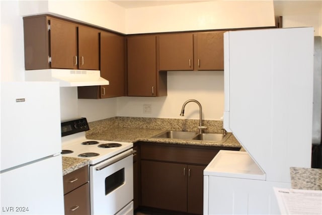 kitchen with a sink, white appliances, under cabinet range hood, and light countertops