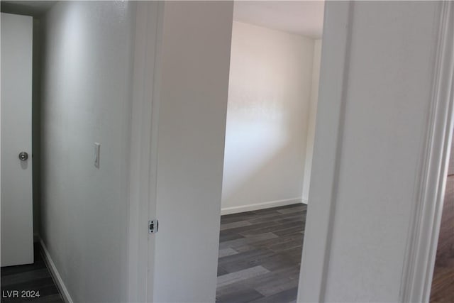 hallway with dark wood-type flooring and baseboards