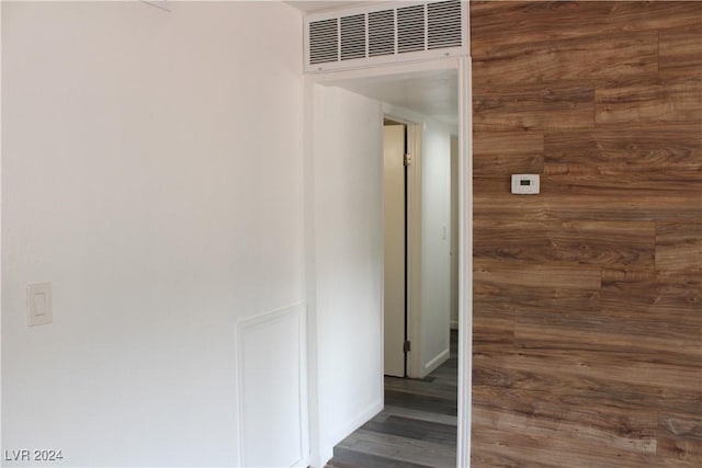 corridor featuring visible vents, baseboards, and wood finished floors