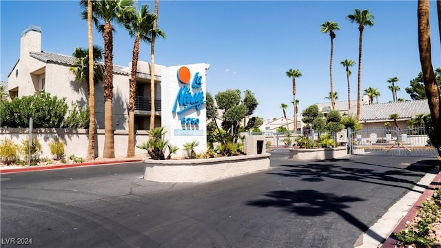 view of road featuring curbs, a gated entry, a residential view, and a gate