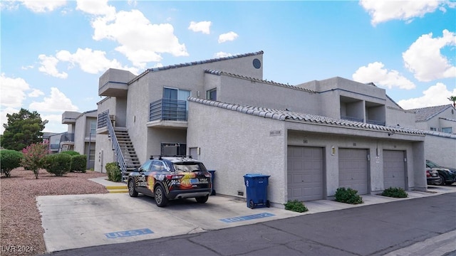 view of building exterior with stairway and an attached garage