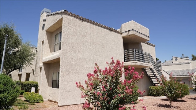 view of home's exterior with stairway and stucco siding