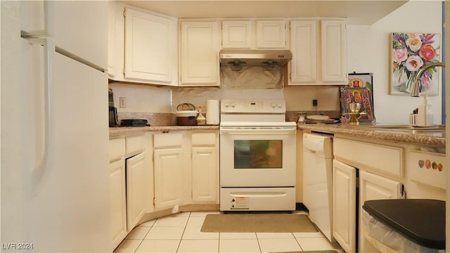 kitchen featuring white appliances, light tile patterned floors, light countertops, under cabinet range hood, and a sink