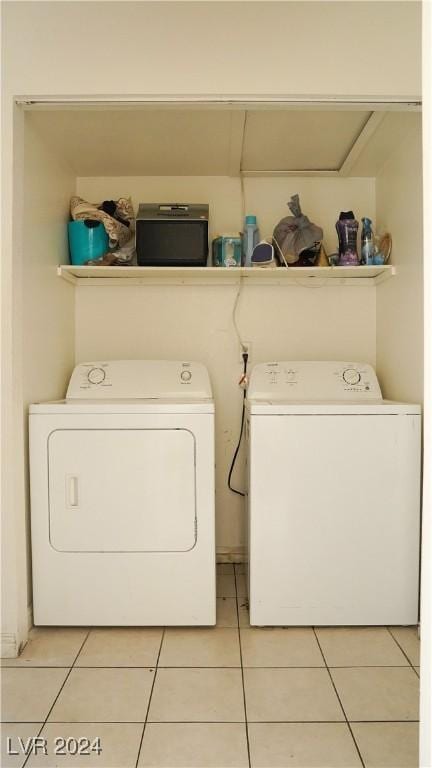 laundry area with laundry area, washer and clothes dryer, and light tile patterned floors