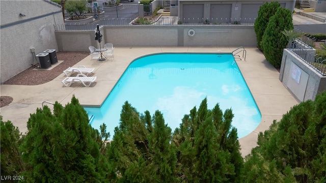 pool with a patio, central AC unit, and fence