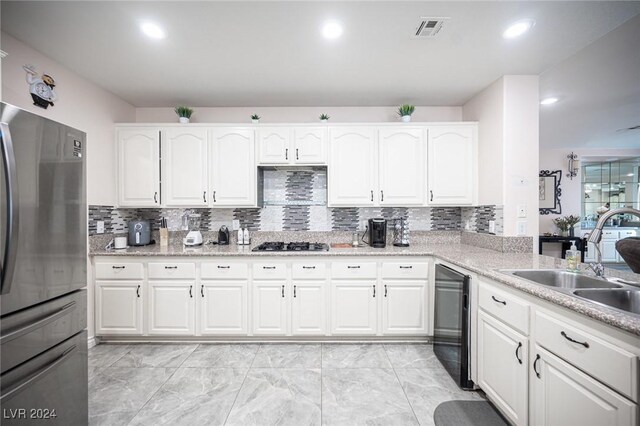 kitchen featuring white cabinetry, stainless steel appliances, sink, and decorative backsplash