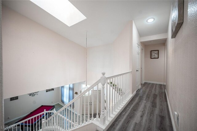 corridor featuring dark hardwood / wood-style floors and a skylight