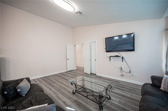 living room with vaulted ceiling and wood-type flooring