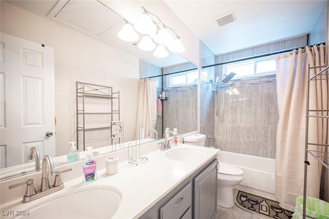 full bathroom with vanity, shower / tub combo with curtain, and toilet