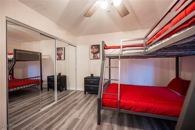 bedroom featuring hardwood / wood-style flooring, ceiling fan, and a closet