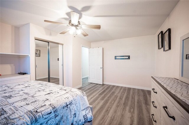 bedroom with hardwood / wood-style flooring, ceiling fan, and a closet