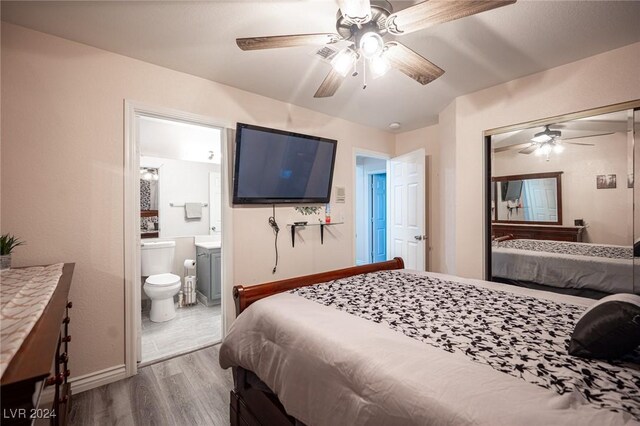 bedroom with ceiling fan, hardwood / wood-style floors, ensuite bath, and a closet