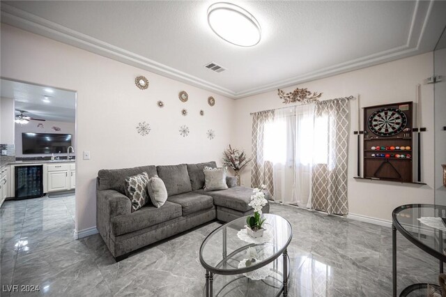 living room with wine cooler, sink, and a textured ceiling