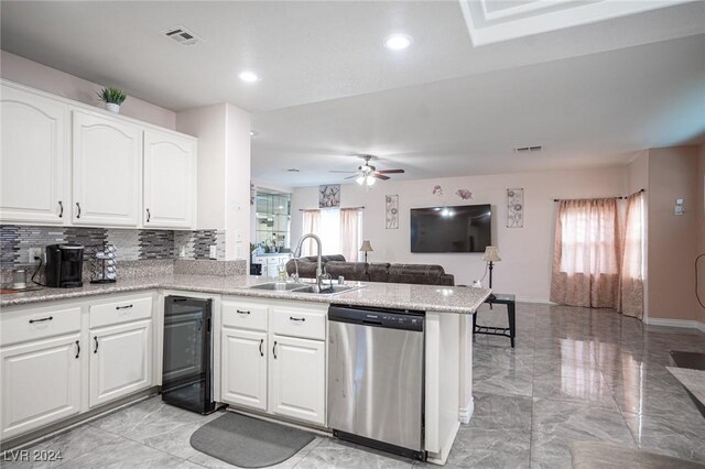 kitchen with sink, dishwasher, kitchen peninsula, decorative backsplash, and white cabinets