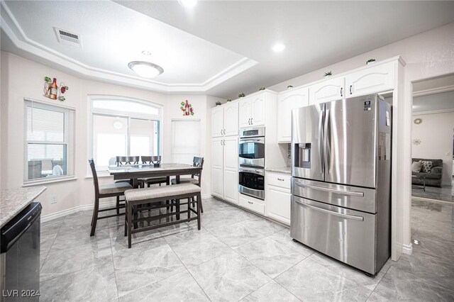 kitchen with white cabinetry, a tray ceiling, and stainless steel appliances