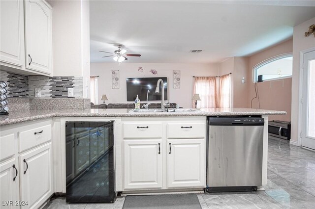 kitchen with white cabinetry, sink, beverage cooler, stainless steel dishwasher, and kitchen peninsula