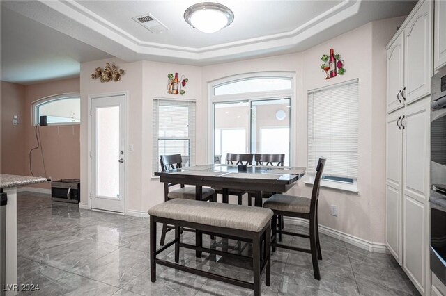 dining space with a raised ceiling