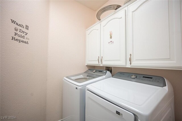 laundry area with washer and clothes dryer and cabinets