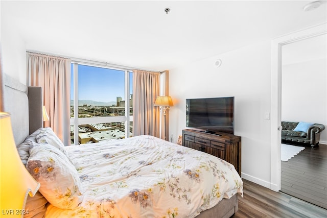 bedroom featuring expansive windows and dark hardwood / wood-style flooring