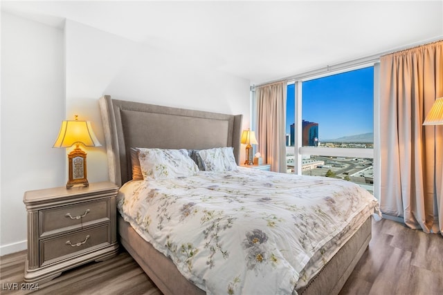 bedroom with expansive windows and hardwood / wood-style floors