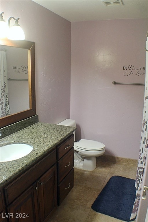 bathroom featuring tile patterned flooring, toilet, and vanity