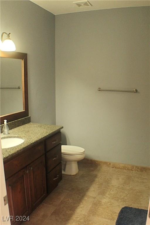 bathroom with visible vents, vanity, and toilet