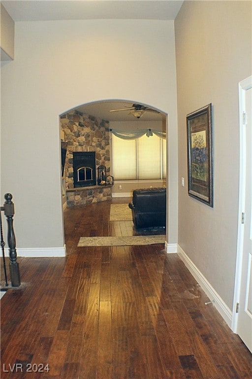 unfurnished living room featuring dark wood-type flooring, a fireplace, and ceiling fan