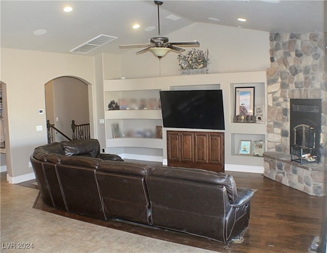 living room with built in features, vaulted ceiling, a fireplace, ceiling fan, and wood-type flooring